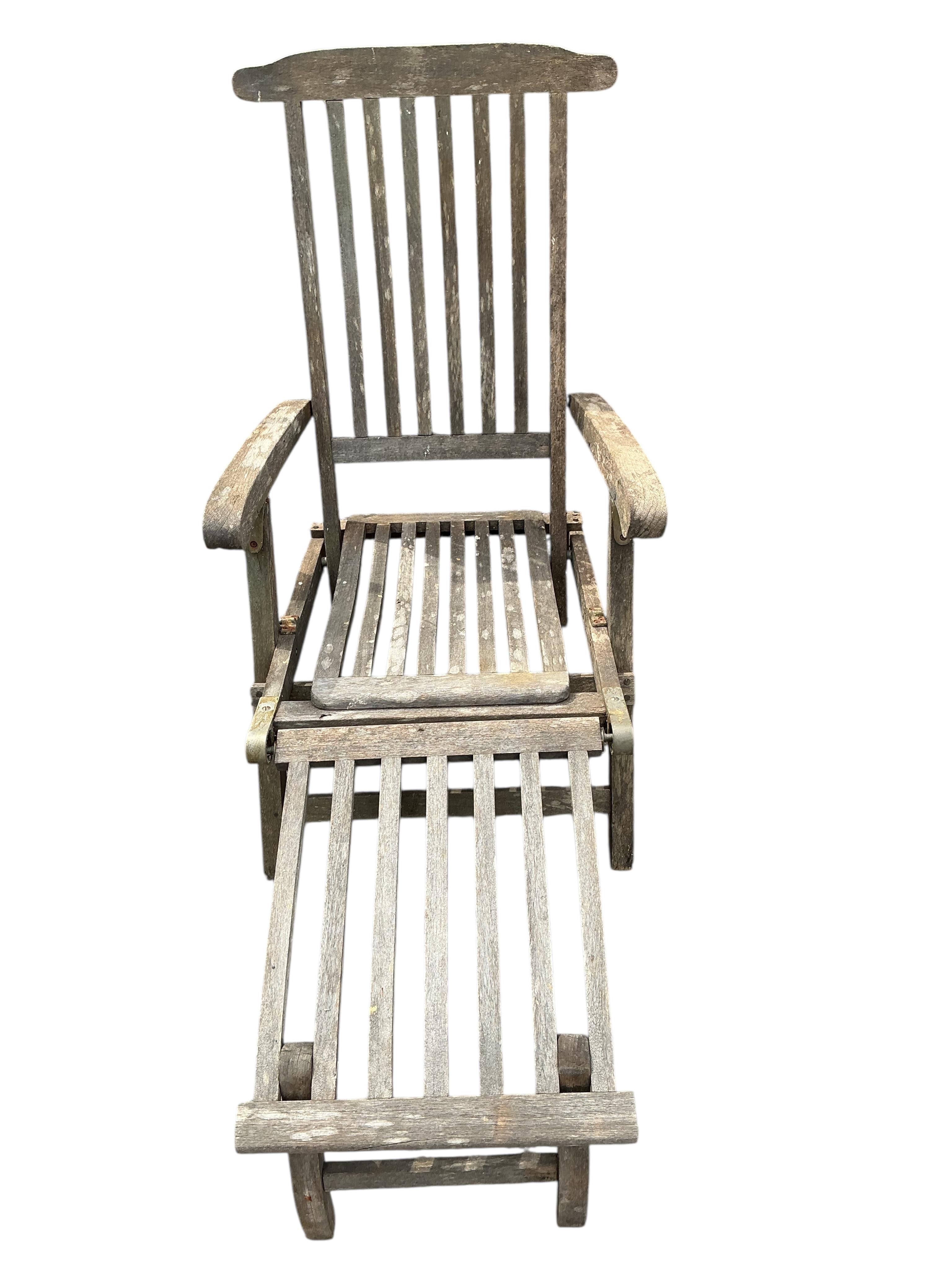 A pair of weathered teak garden steamer chairs